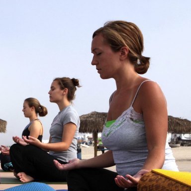 Tre personer som sitter i lotusposisjon